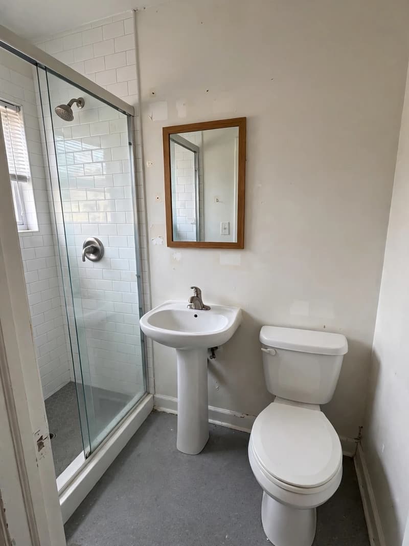 Clean empty rental bathroom with hooks removed and spotless surfaces ready for inspection